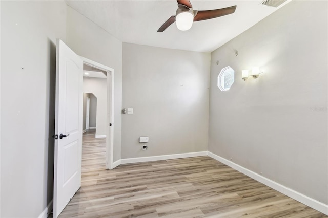 empty room featuring light wood-style flooring, a ceiling fan, and baseboards