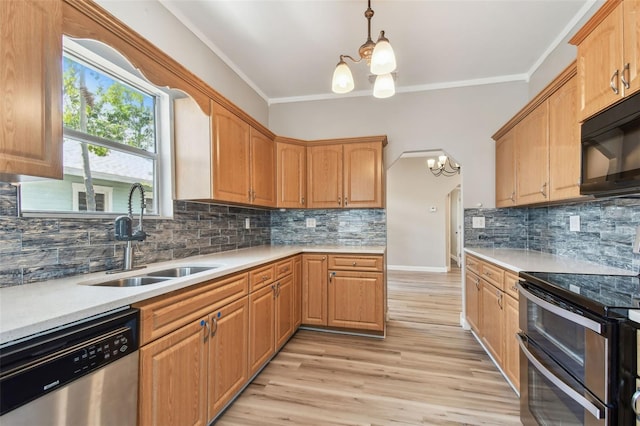 kitchen featuring tasteful backsplash, light wood-style flooring, appliances with stainless steel finishes, and a sink