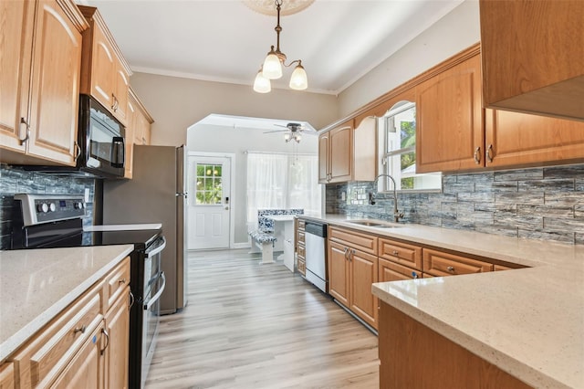 kitchen with backsplash, appliances with stainless steel finishes, light stone countertops, and a sink