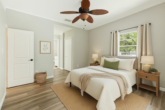 bedroom with visible vents, light wood-style flooring, baseboards, and a closet