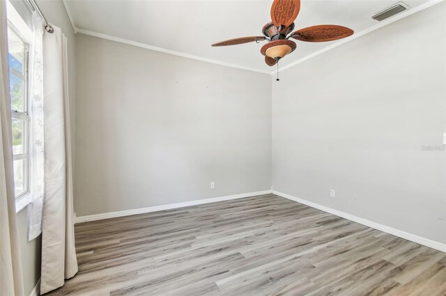 empty room with wood finished floors, visible vents, and baseboards