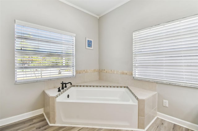bathroom featuring a garden tub, crown molding, wood finished floors, and baseboards