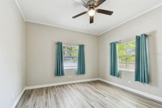 spare room with baseboards, crown molding, and wood finished floors