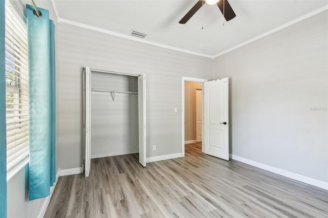 unfurnished bedroom with visible vents, baseboards, wood finished floors, a closet, and ceiling fan