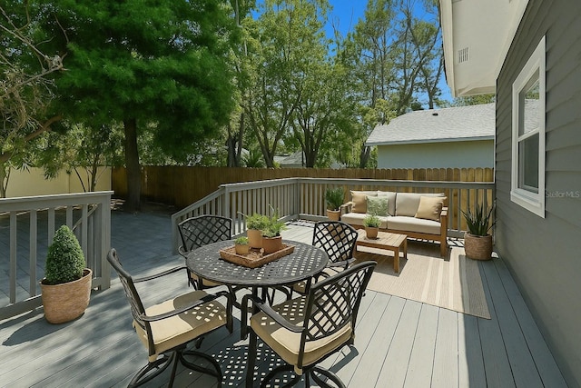wooden deck featuring a fenced backyard, an outdoor living space, and outdoor dining space