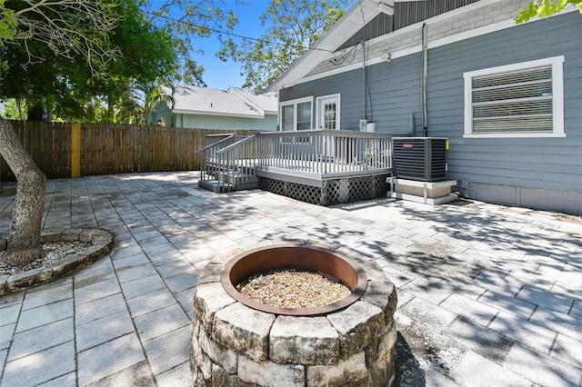 view of patio with fence, a deck, cooling unit, and an outdoor fire pit