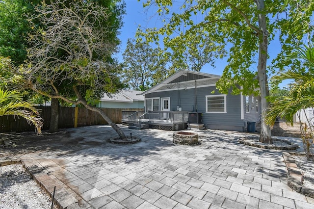 back of house with central air condition unit, an outdoor fire pit, fence, a patio, and a wooden deck