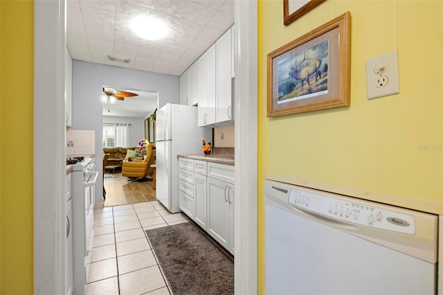 kitchen with visible vents, white appliances, white cabinets, and light tile patterned floors