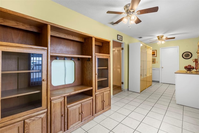 unfurnished living room featuring a ceiling fan, visible vents, and light tile patterned floors