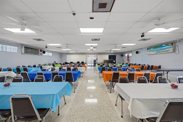 interior space with light speckled floor, visible vents, a ceiling fan, and a drop ceiling