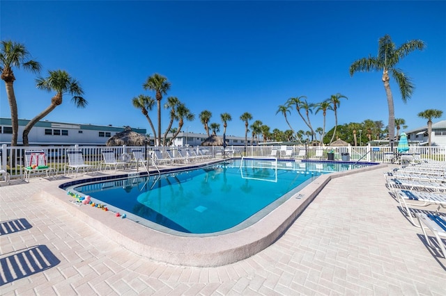 pool featuring fence and a patio area