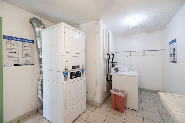 shared laundry area featuring baseboards, stacked washing maching and dryer, and light tile patterned floors