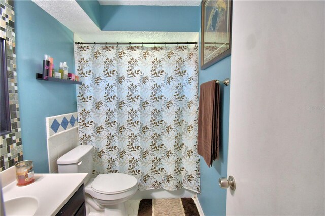 53 Paine Dr, Winter Haven, FL 33884 - full bath featuring tile patterned flooring, tile walls, toilet, and vanity