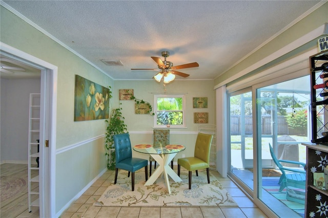 53 Paine Dr, Winter Haven, FL 33884 - dining space with tile patterned floors, a wainscoted wall, a textured ceiling, a ceiling fan, and ornamental molding