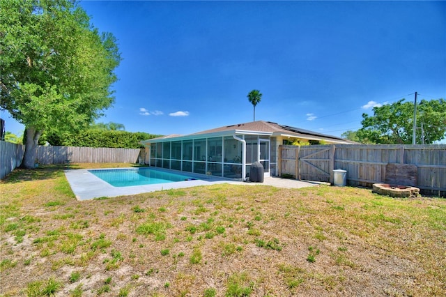53 Paine Dr, Winter Haven, FL 33884 - back of property featuring a fenced in pool, a sunroom, a fenced backyard, and a lawn