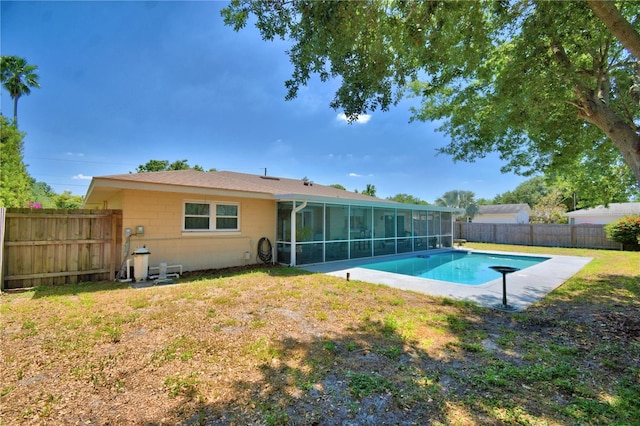 53 Paine Dr, Winter Haven, FL 33884 - back of house with concrete block siding, a fenced in pool, a fenced backyard, a lawn, and a sunroom