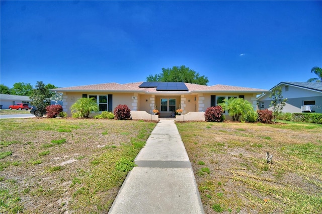 53 Paine Dr, Winter Haven, FL 33884 - single story home featuring stucco siding, a front yard, and solar panels