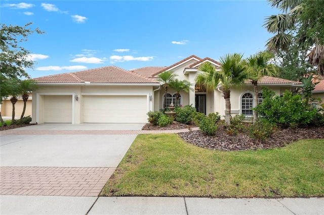 17206 Emerald Chase Dr, Tampa, FL 33647 - mediterranean / spanish home featuring a front lawn, decorative driveway, stucco siding, a tiled roof, and an attached garage