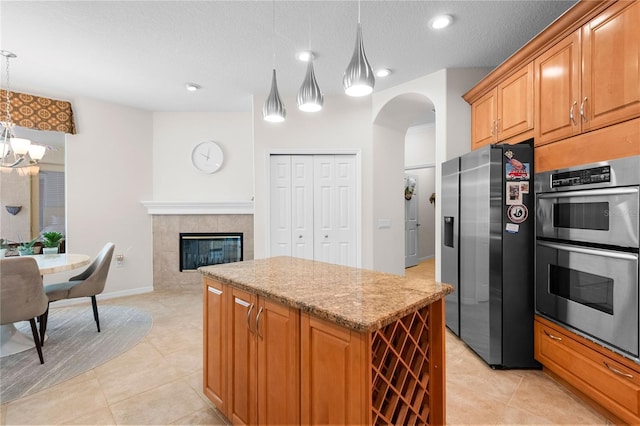 17206 Emerald Chase Dr, Tampa, FL 33647 - kitchen featuring light tile patterned flooring, a center island, a chandelier, arched walkways, and stainless steel appliances