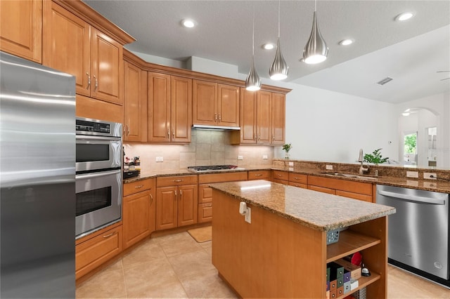 17206 Emerald Chase Dr, Tampa, FL 33647 - kitchen featuring appliances with stainless steel finishes, a sink, arched walkways, a center island, and visible vents
