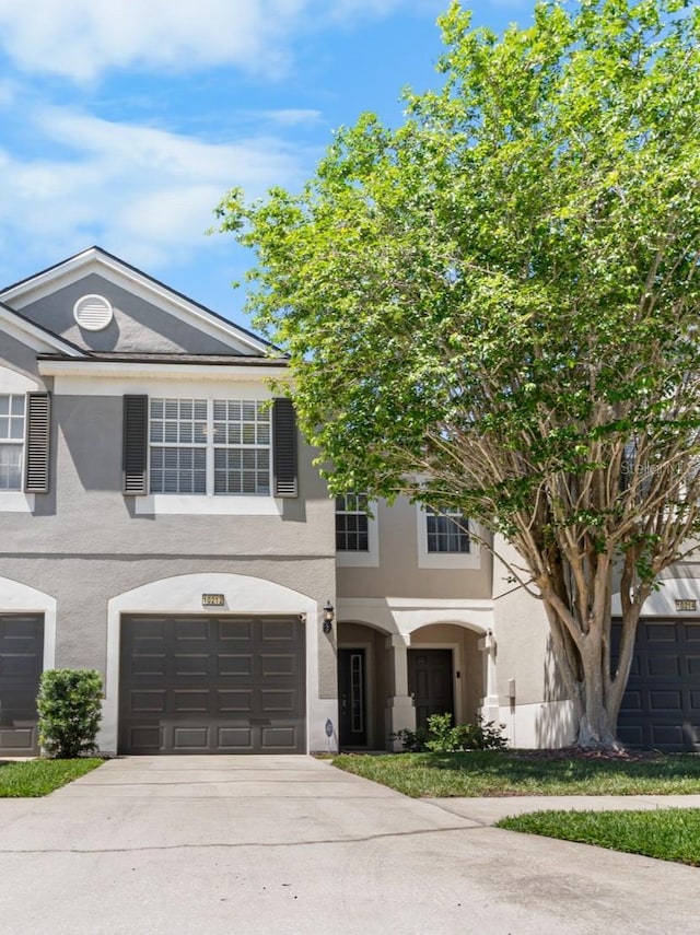 view of front of property with driveway, a garage, and stucco siding