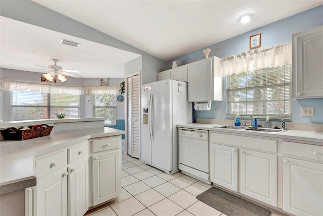 kitchen with a sink, white appliances, a ceiling fan, visible vents, and light countertops