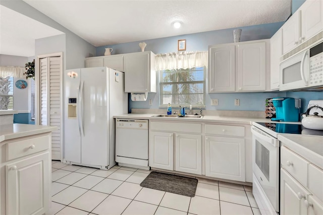 kitchen featuring plenty of natural light, a sink, light countertops, and white appliances
