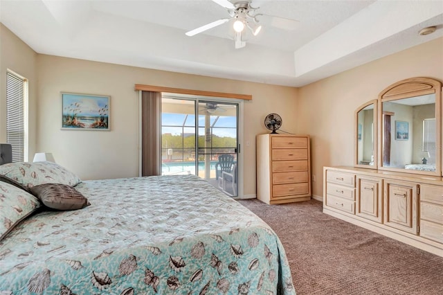 bedroom featuring access to outside, a tray ceiling, a ceiling fan, baseboards, and carpet floors