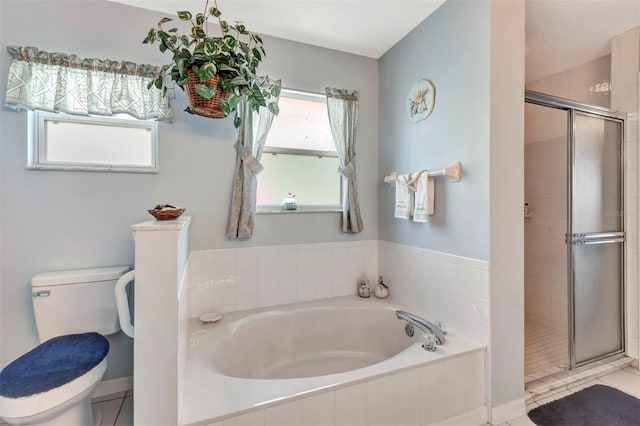 bathroom with a stall shower, toilet, and a garden tub