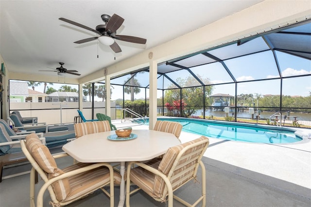 pool with ceiling fan, a water view, a patio, and glass enclosure
