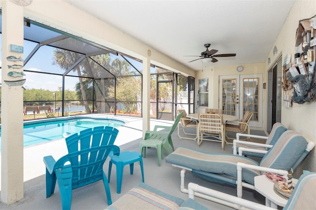 outdoor pool with a ceiling fan, a patio, french doors, and glass enclosure