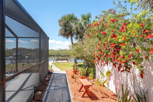 view of yard featuring a boat dock, a water view, and a lanai