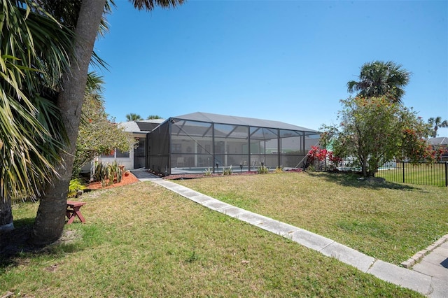 view of yard featuring fence, a lanai, and a swimming pool