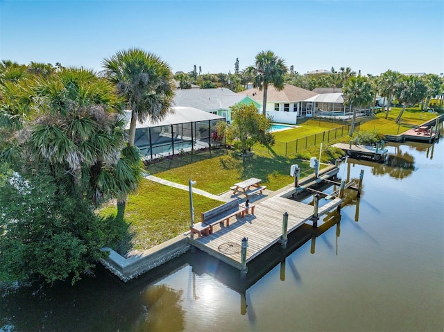 dock area featuring a fenced in pool, boat lift, a water view, fence, and a yard