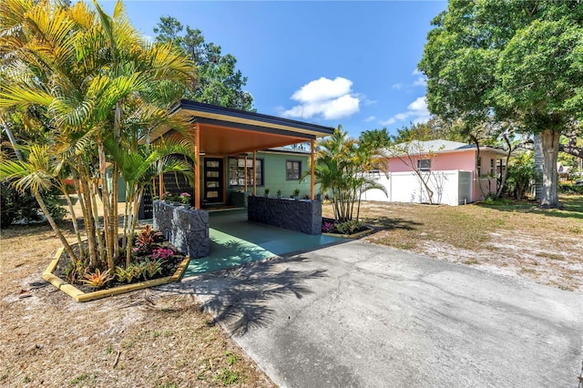 exterior space featuring fence, a carport, and driveway