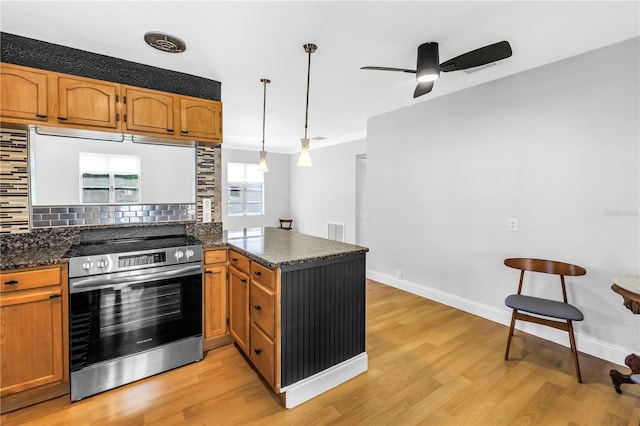 kitchen featuring stainless steel electric range oven, decorative backsplash, light wood-style flooring, a peninsula, and a ceiling fan