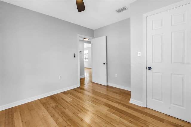 unfurnished bedroom featuring ceiling fan, visible vents, light wood-type flooring, and baseboards