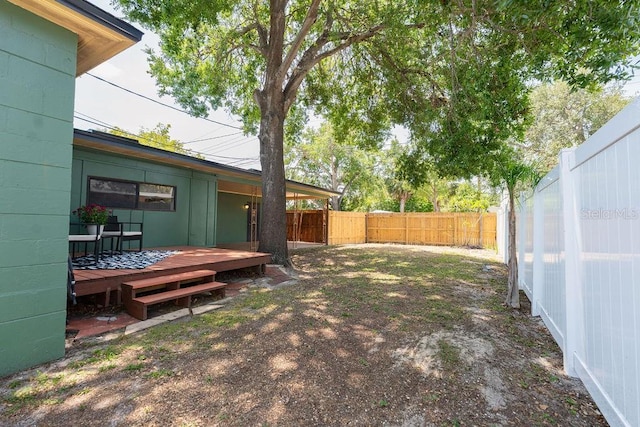 view of yard with a deck and a fenced backyard