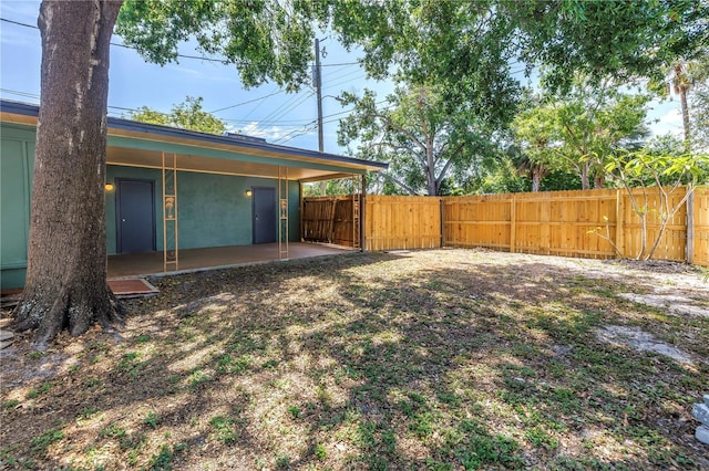 view of yard with fence, a gate, and a patio area