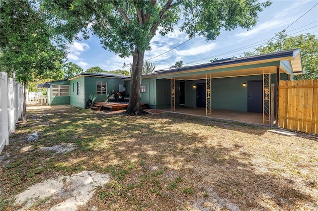 back of property with a patio, a wooden deck, and a fenced backyard