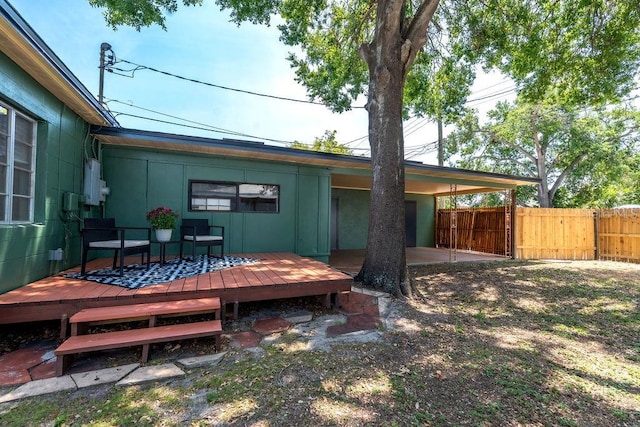 rear view of house featuring fence, a wooden deck, and board and batten siding