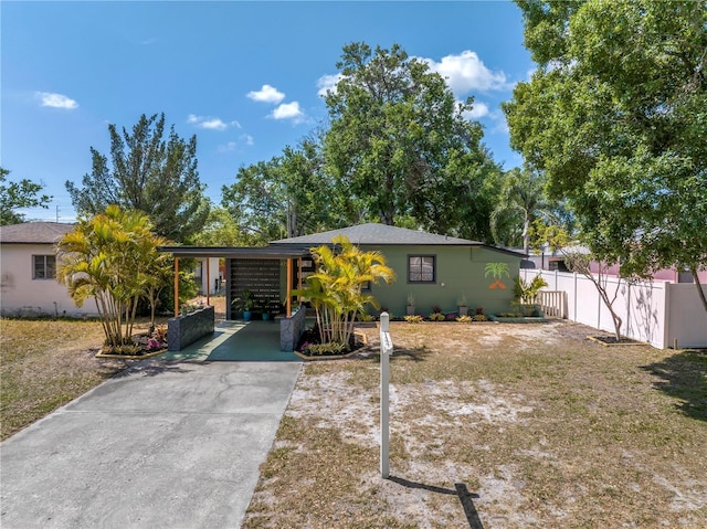 ranch-style house with driveway and fence