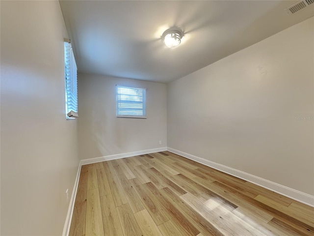 spare room with visible vents, baseboards, and light wood finished floors