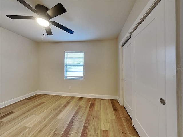 unfurnished bedroom with a closet, light wood finished floors, baseboards, and ceiling fan