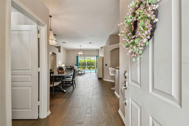 6006 Chellas Ct, Lutz, FL 33558 - foyer entrance with arched walkways, baseboards, and dark wood-type flooring