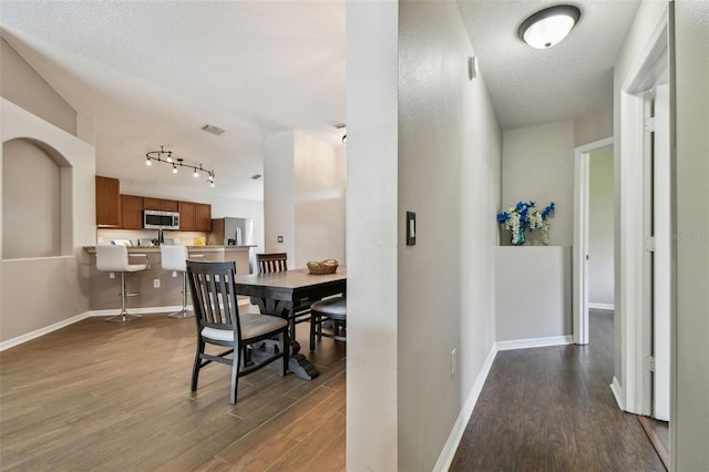 6006 Chellas Ct, Lutz, FL 33558 - hallway with track lighting, baseboards, visible vents, and dark wood-type flooring