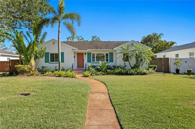 ranch-style house with fence, a front yard, and stucco siding