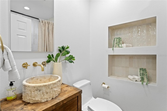 full bath featuring vanity and toilet