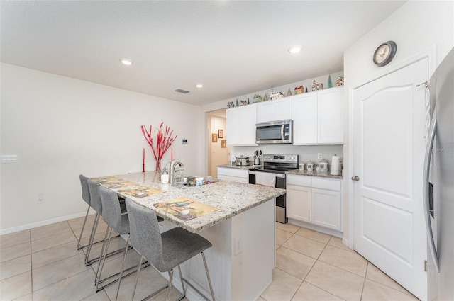 947 Serchio St, Haines City, FL 33844 - kitchen with a breakfast bar, light tile patterned floors, light stone countertops, visible vents, and stainless steel appliances