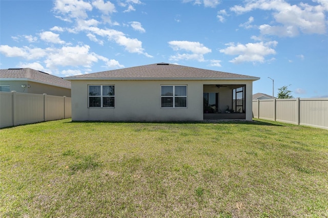 947 Serchio St, Haines City, FL 33844 - rear view of property with a fenced backyard, a ceiling fan, a lawn, and stucco siding
